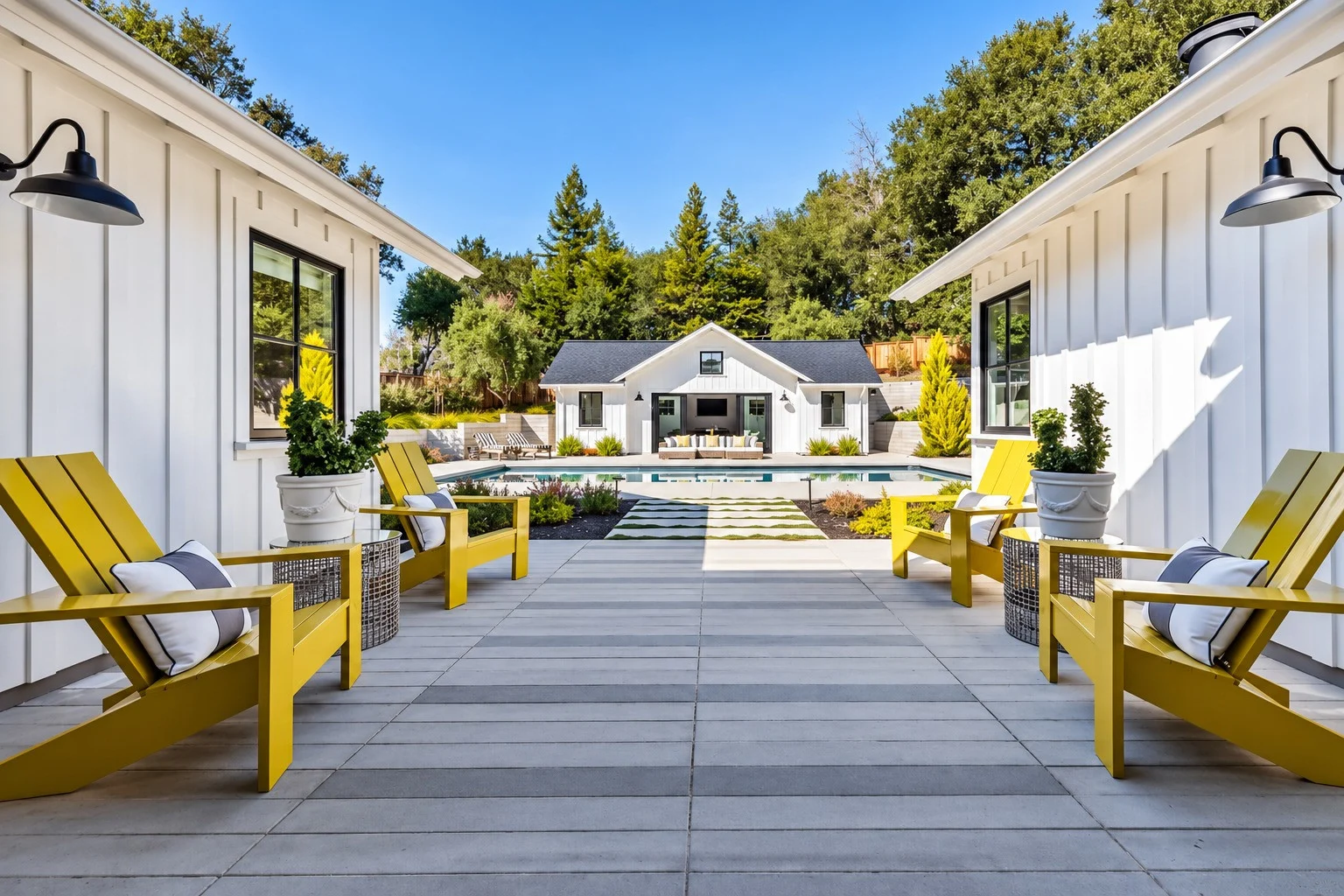 Covered Breezeway with Yellow Adirondack Chairs A stucco and tile-roofed estate with a curved driveway, crepe myrtle in bloom, and ornamental grasses