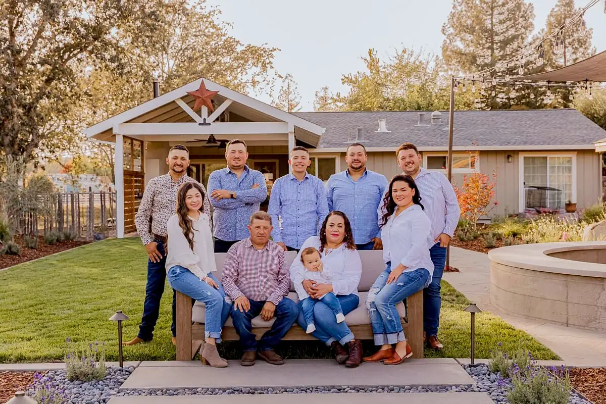 The Highland family seated and standing together in a garden, with a covered patio behind them